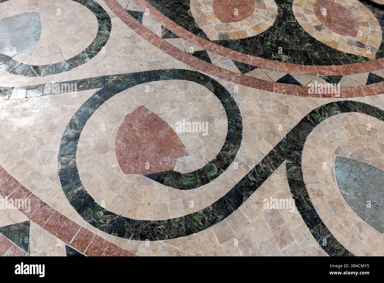 Design géométrique complexe sur un sol carrelé mettant en valeur l'artisanat artistique avec des couleurs vives et des motifs floraux Banque D'Images
