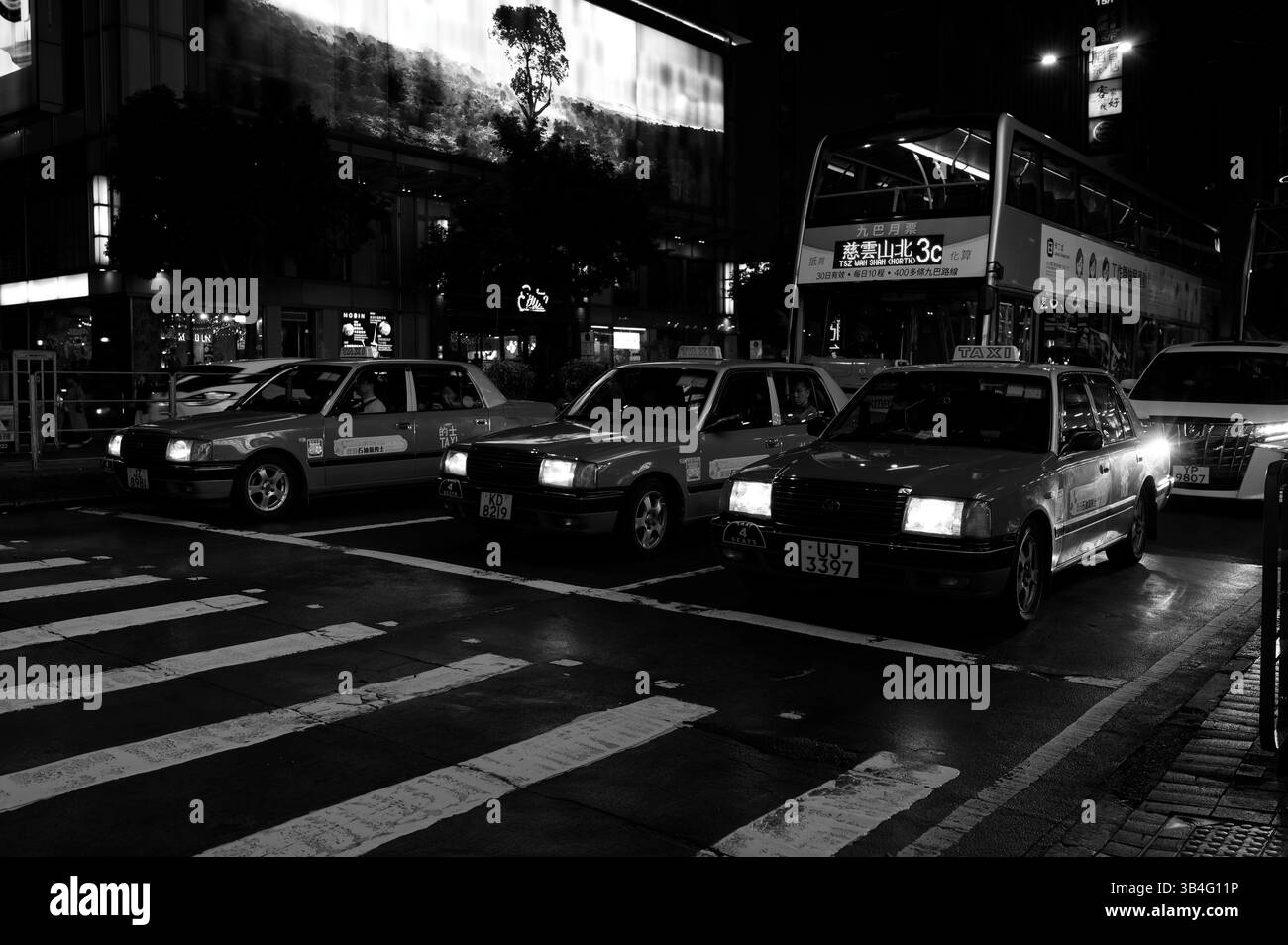 Hong Kong - 2 février 2025 - les taxis emblématiques de Hong Kong se dressent sous la lueur de la ville Banque D'Images