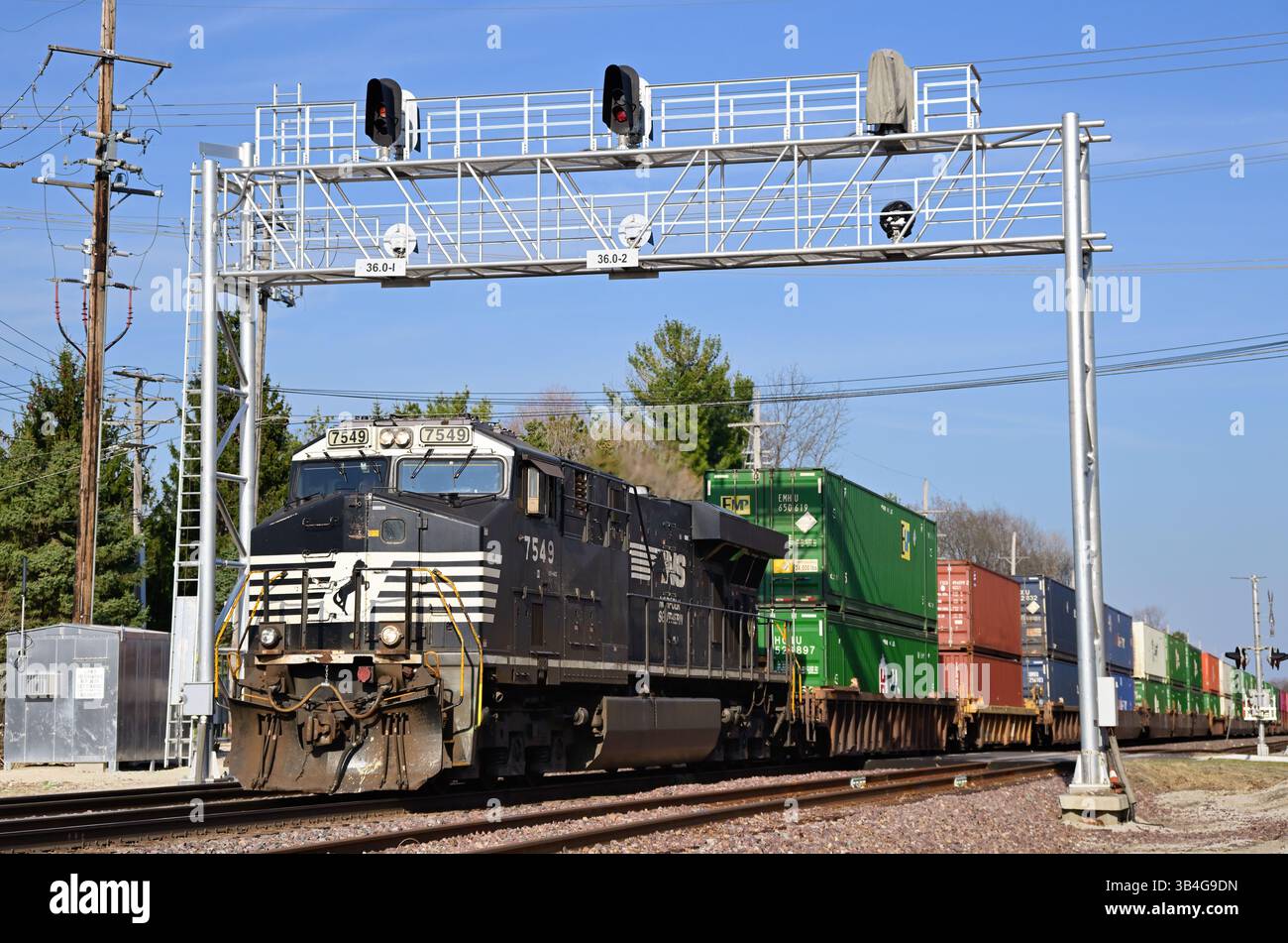 Genève, Illinois, États-Unis. Une locomsotive du Norfolk Southern Railway dirige un train de marchandises intermodal de l'Union Pacific Railroad en direction de l'ouest. Banque D'Images