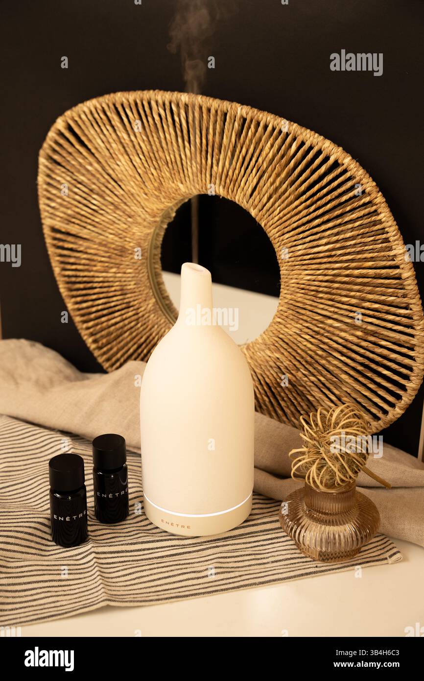 Composition artistique – vase blanc et miroir tissé circulaire avec accent noir Banque D'Images