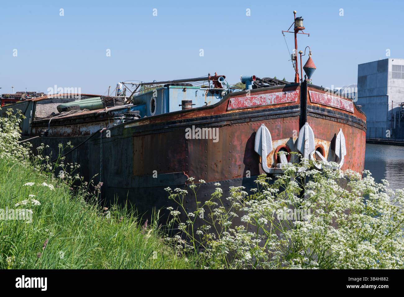 Un bateau usé et rouillé, orné de quelques vieilles ancres reposant dessus, signifie des années d'aventures maritimes et d'histoires inédites Banque D'Images