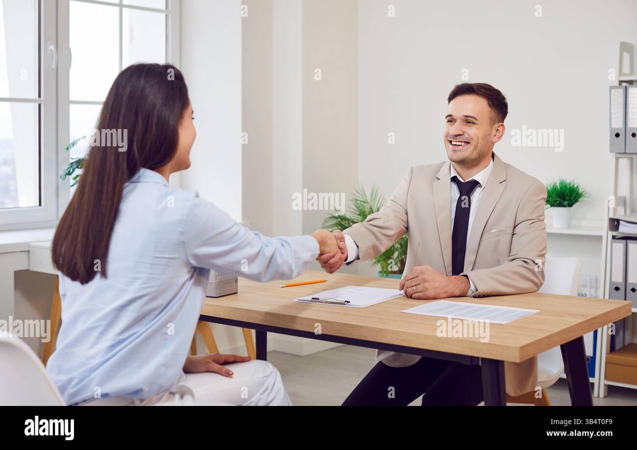Souriant deux hommes d'affaires, heureux hommes, femmes entrepreneurs se serrant la main après avoir discuté Banque D'Images