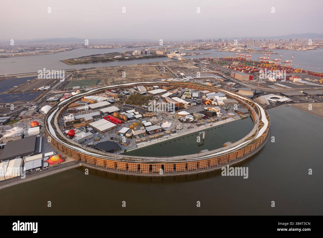 Vue aérienne d'Osaka Expo 2025 Japon, vue en hélicoptère du coucher du soleil du Grand Ring et des pavillons de campagne sur l'île de Yumeshimanaka Banque D'Images