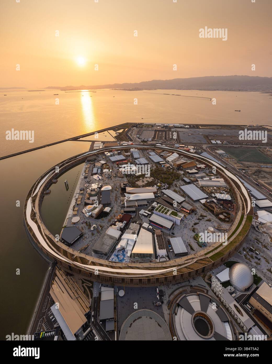 Vue aérienne d'Osaka Expo 2025 Japon, vue en hélicoptère du coucher du soleil du Grand Ring et des pavillons de campagne sur l'île de Yumeshimanaka Banque D'Images
