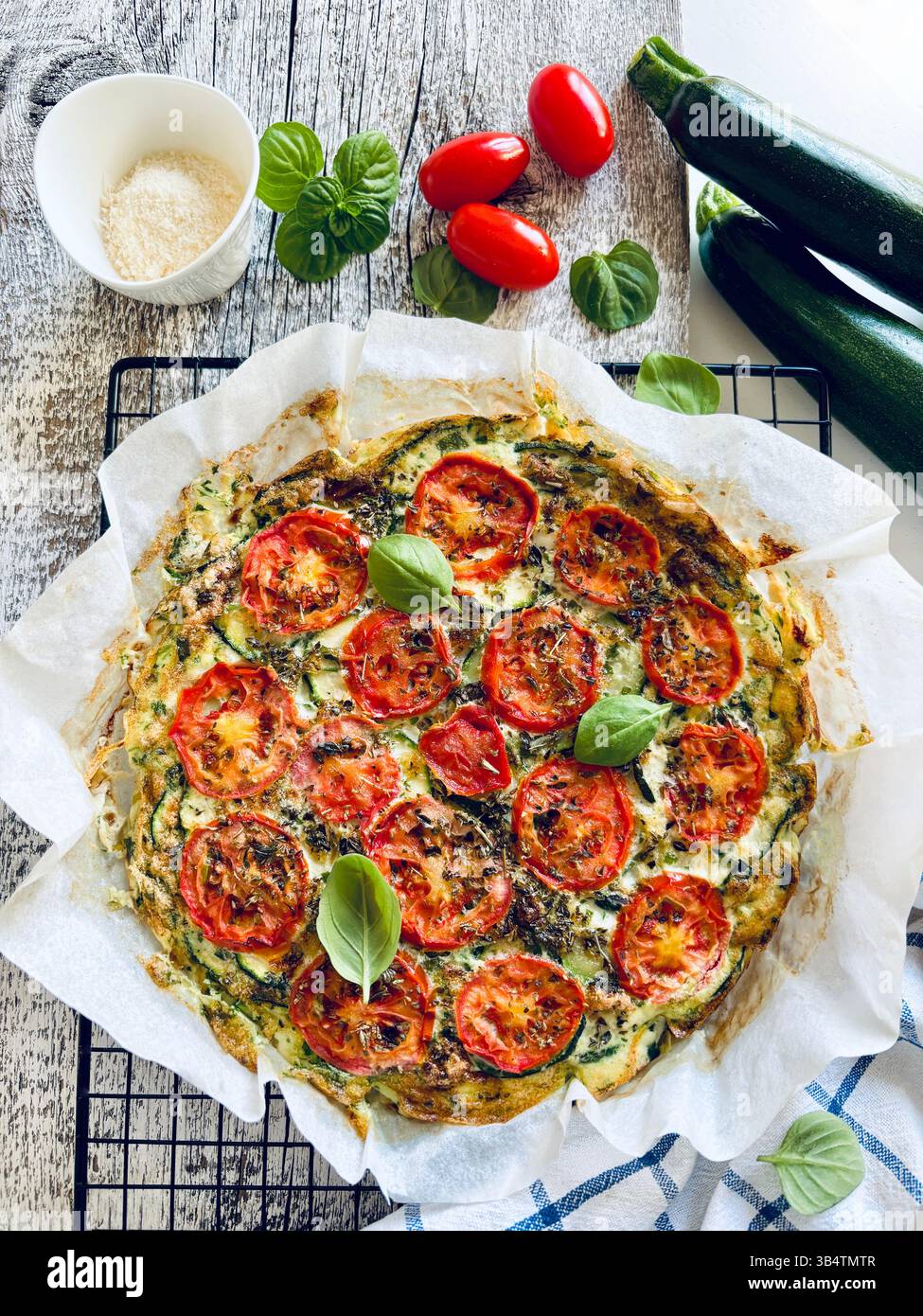 Frittata maison cuite au four avec des légumes tels que courgettes, tomates, œufs et basilic. Nourriture saine. Nourriture estivale. Directement au-dessus. Banque D'Images