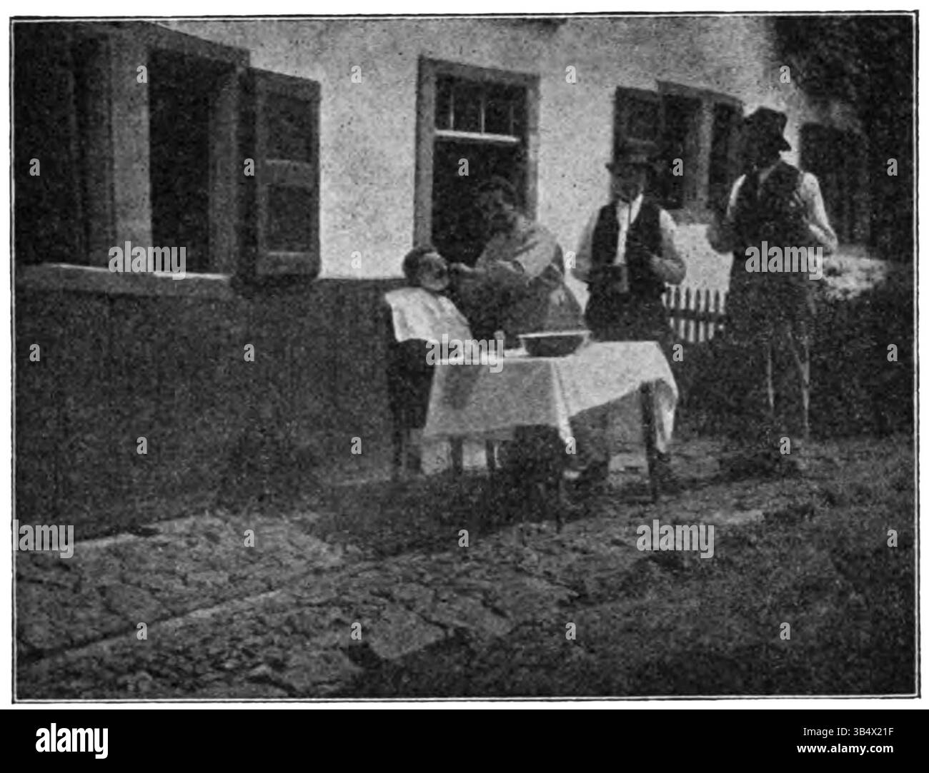 Cette photographie, trouvée à la page 217 du livre 'Wandelen en Waarnemen' de 1906 d'Eli Heimans, montre un barbier à Epen. L'image capture la vie quotidienne dans un petit village rural, illustrant les métiers locaux et la simplicité de la vie au début du XXe siècle. Banque D'Images