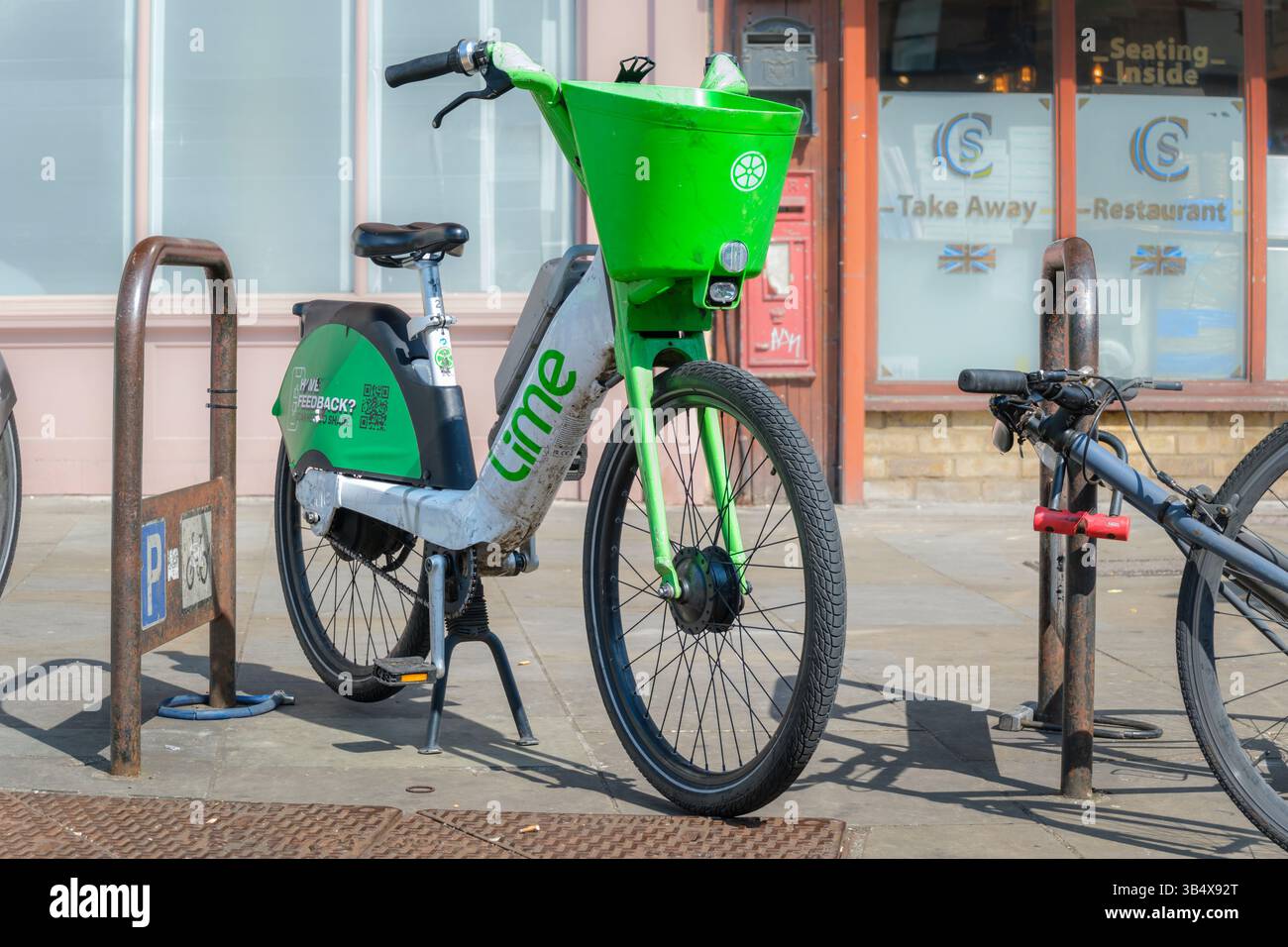 Londres, Angleterre - Un vélo électrique Lime Dockless à côté d'un support de vélo tubulaire dans le centre de Londres. Banque D'Images