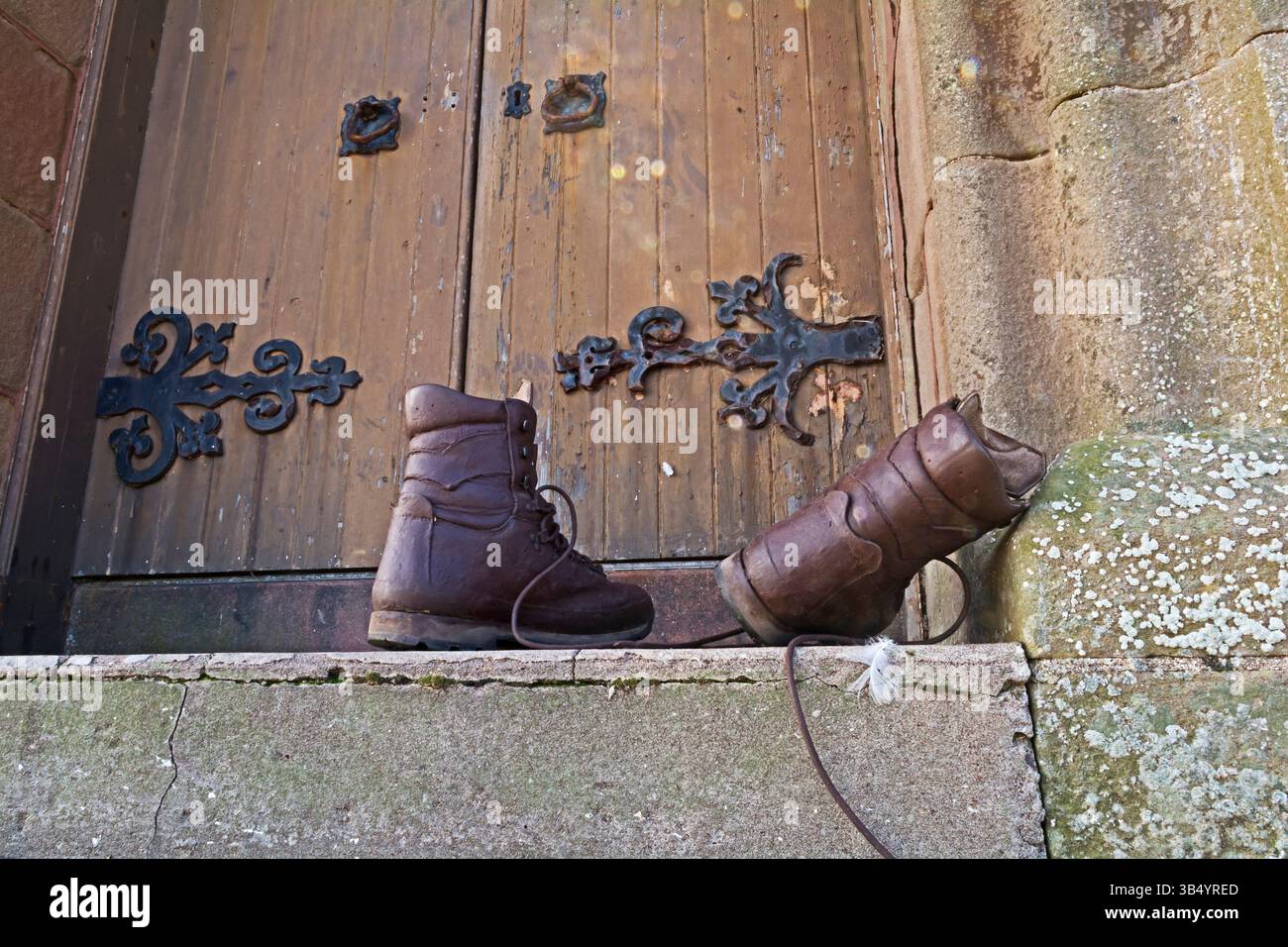 Une paire de bottes de marche sur les marches d'une église ou d'un vieux bâtiment classique Banque D'Images