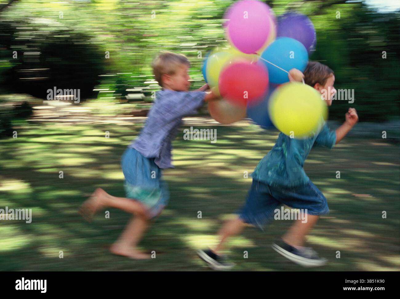 Les garçons en exécutant le jardin avec partie des ballons. Banque D'Images