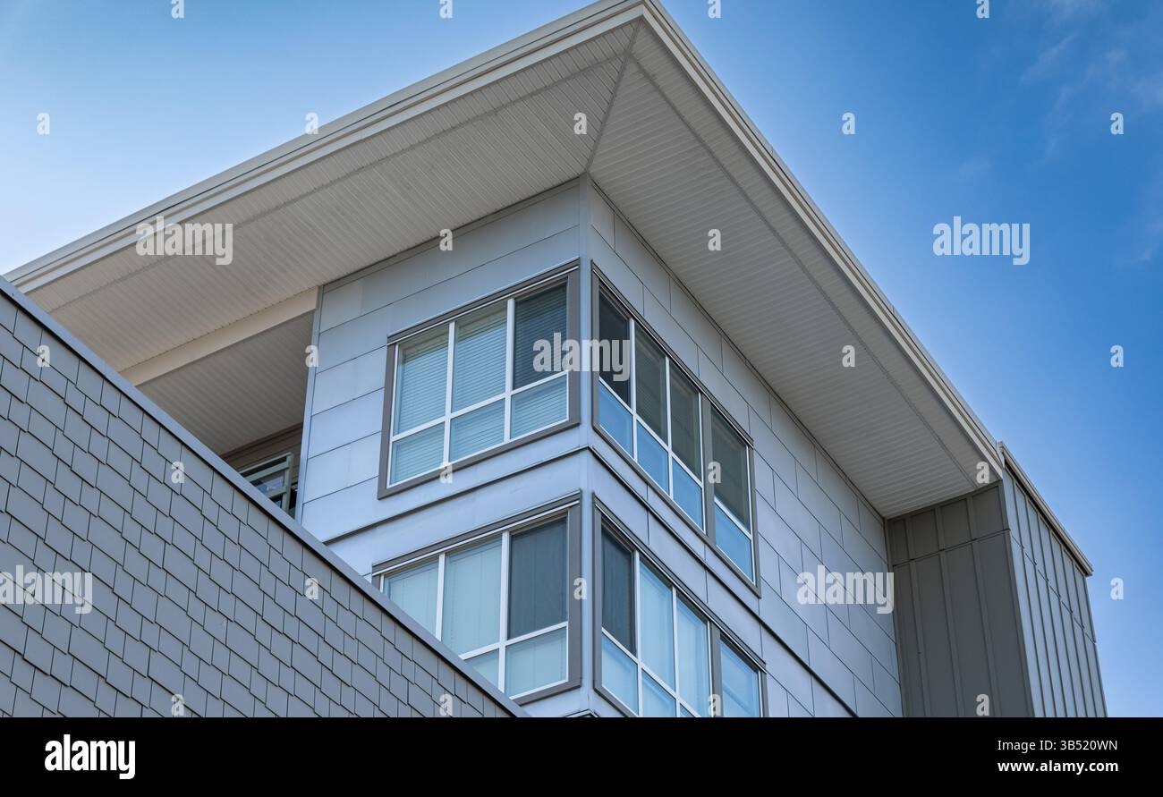 Haut d'une maison de ville avec de belles fenêtres. Dormer avec fond de ciel bleu. Extérieur de la maison moderne. Immobilier extérieur Front House à quartier résidentiel Banque D'Images