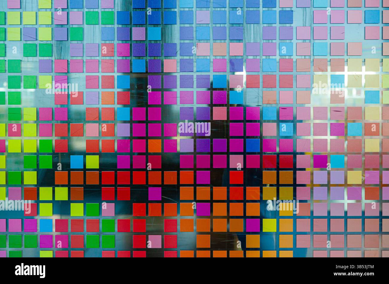 Mosaïque de petits carrés multicolores sur verre, gros plan. Carrés numériques multicolores de style matriciel. Banque D'Images