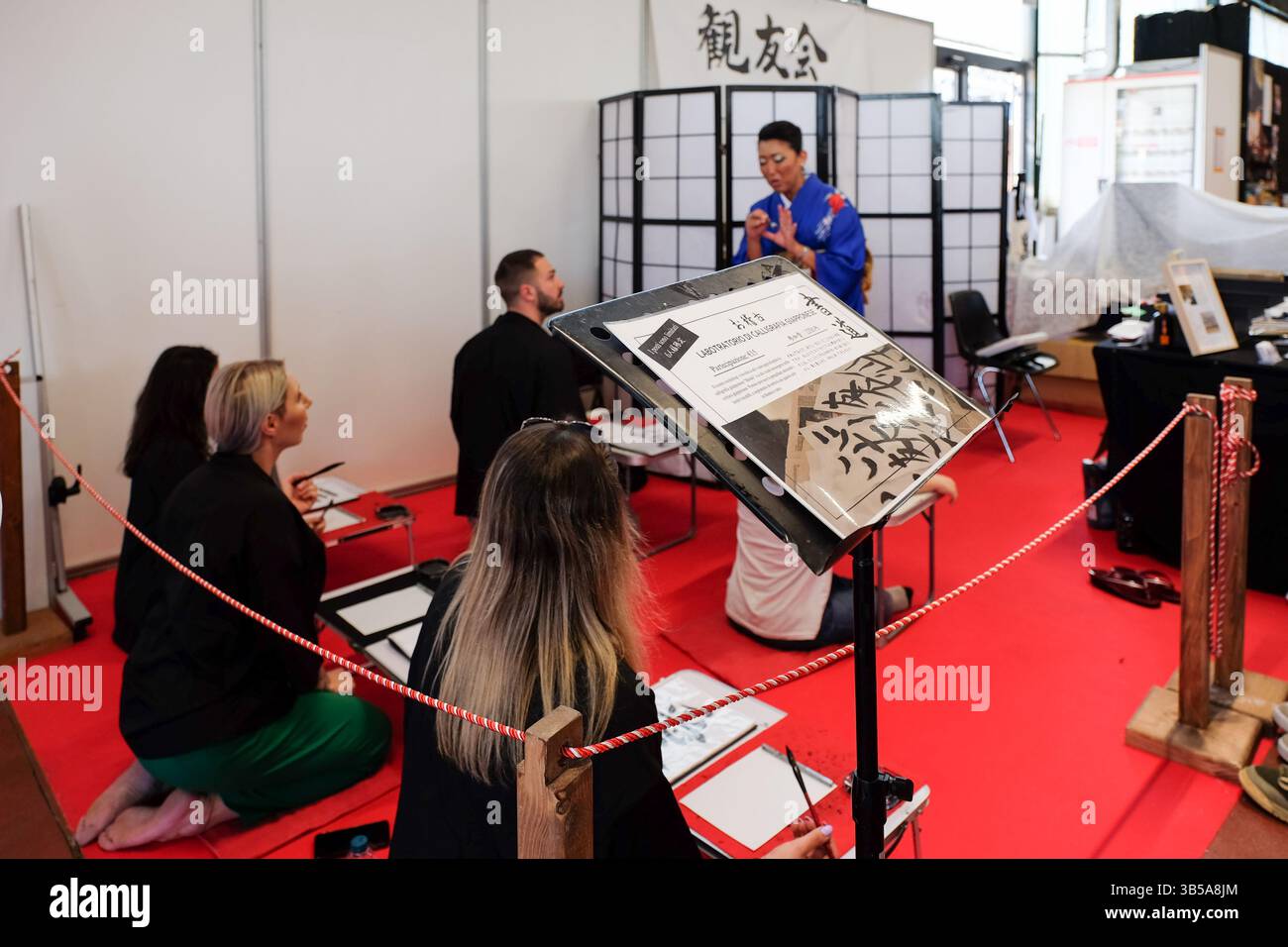 Milan, Italie. 1er mai 2025. Un atelier de calligraphie japonaise a lieu au Festival dell'Oriente, où les participants apprennent les bases de l'écriture au pinceau. Banque D'Images