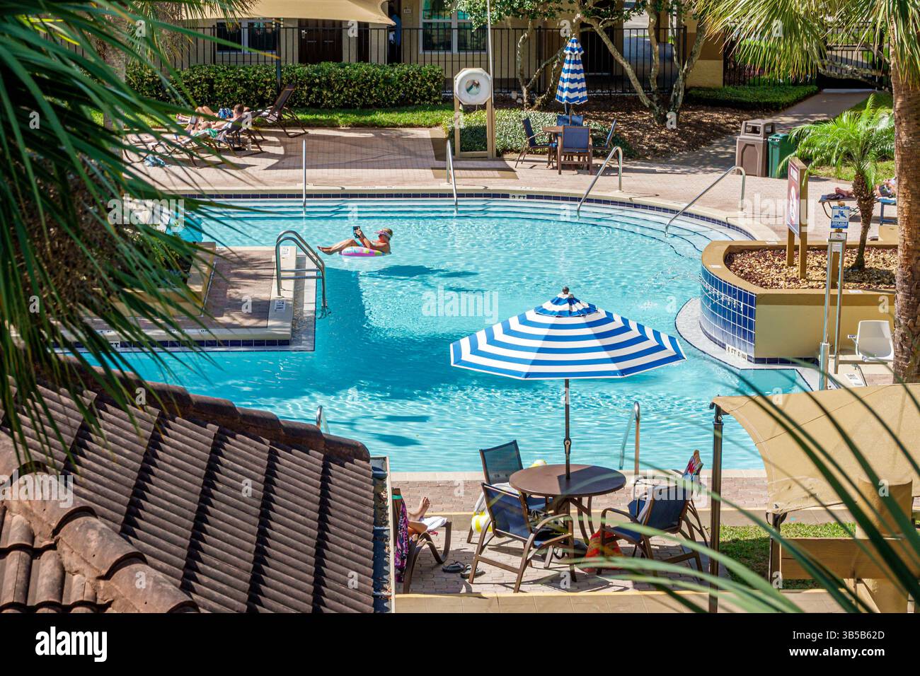 Orlando Floride, Lake Buena Vista, Blue Tree Resort à Lake Buena Vista, piscine extérieure, piscine de l'hôtel, parasols blancs rayés, détente l Banque D'Images