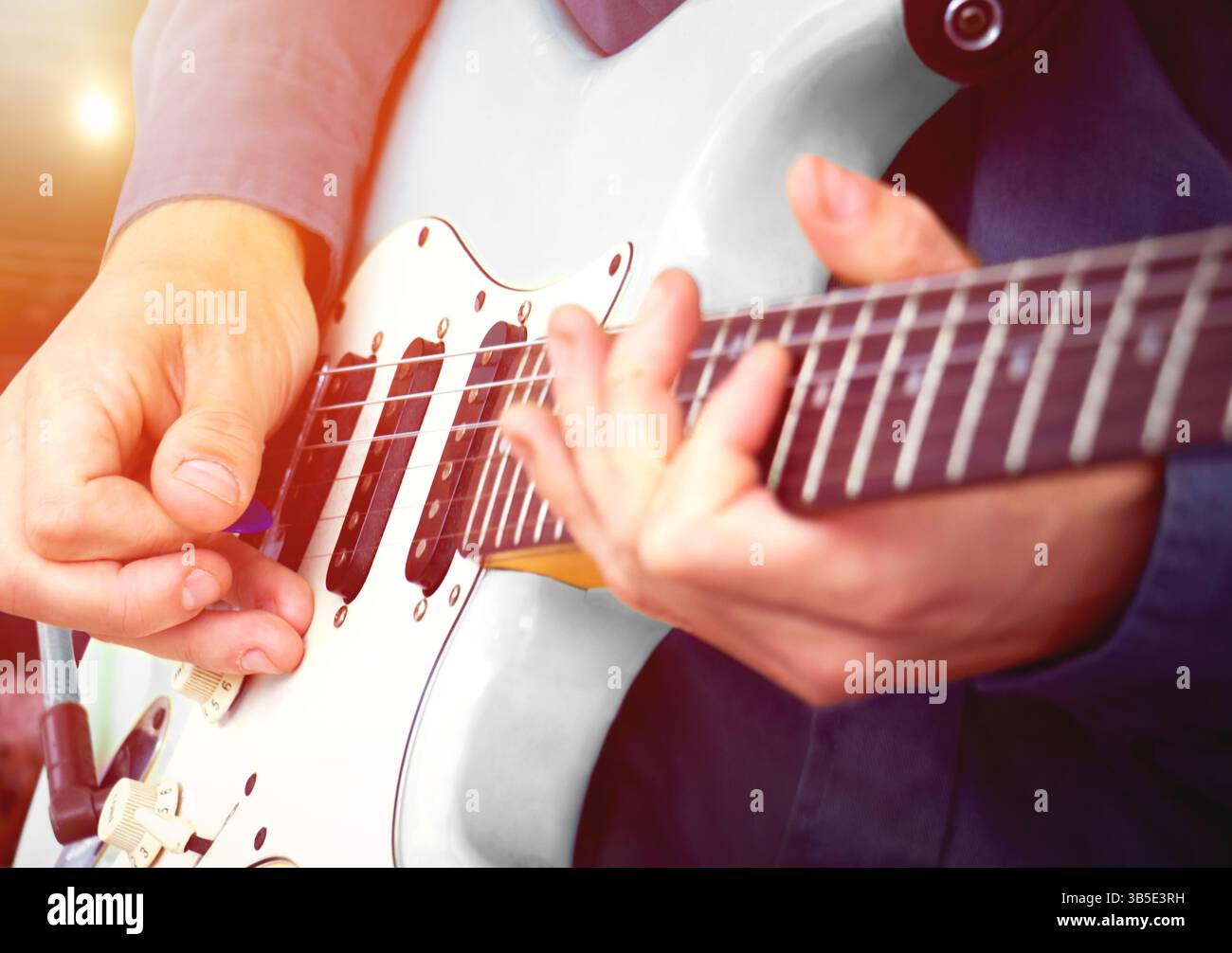 Performance musicale live par guitariste – musicien jouant de la guitare électrique contre les lumières de scène dans la salle de concert. Banque D'Images
