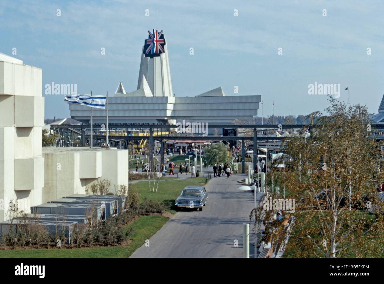 Une vue de l'Expo 67, Montréal, Québec, Canada en 1967. Derrière le pavillon d'Israël (à gauche) se trouve le pavillon de la Grande-Bretagne. L'architecte britannique Sir Basil Spence a conçu le pavillon, qui utilisait des charpentes en acier et des feuilles d'amiante. La tour était surmontée d'un drapeau de l'union Jack 3D. Le site rond du système de transport surélevé était un monorail à 3 boucles appelé le Minirail. L’exposition universelle (ou exposition universelle, « Expo 67 ») était située sur une île du fleuve Saint-Laurent. Son thème était « L’homme et son monde » – une photographie vintage des années 1960. Banque D'Images