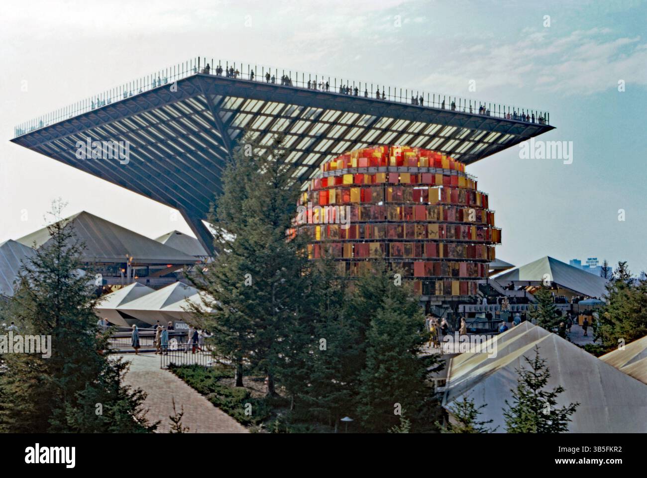 Le Pavillon canadien à Expo 67, Montréal, Québec, Canada en 1967. Le pavillon de la maison présentait une structure pyramidale inversée (Katimavik – arrière). En face est comme une promenade à travers une attraction appelée le « People Tree ». Elle était composée d’images sur du tissu de nylon orange et rouge (feuilles d’arbres), les couleurs représentant les couleurs des feuilles d’automne – la moitié des feuilles portaient des images photographiques sérigraphiées de Canadiens au travail et au jeu. L'architecte Rod Robbie a exigé que le pavillon du Canada soit le plus grand site de la foire (il était de 11,5 acres) - une photographie vintage des années 1960. Banque D'Images