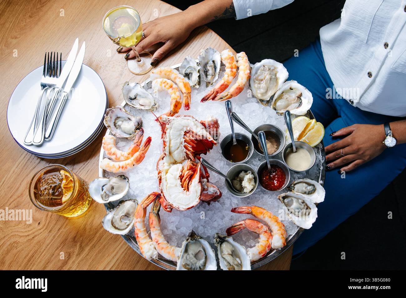 Femme à table avec plateau de fruits de mer Banque D'Images