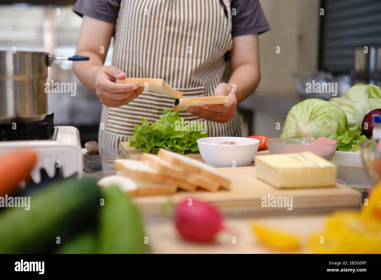 Cuire en préparant un sandwich sain avec des légumes frais et du pain Banque D'Images