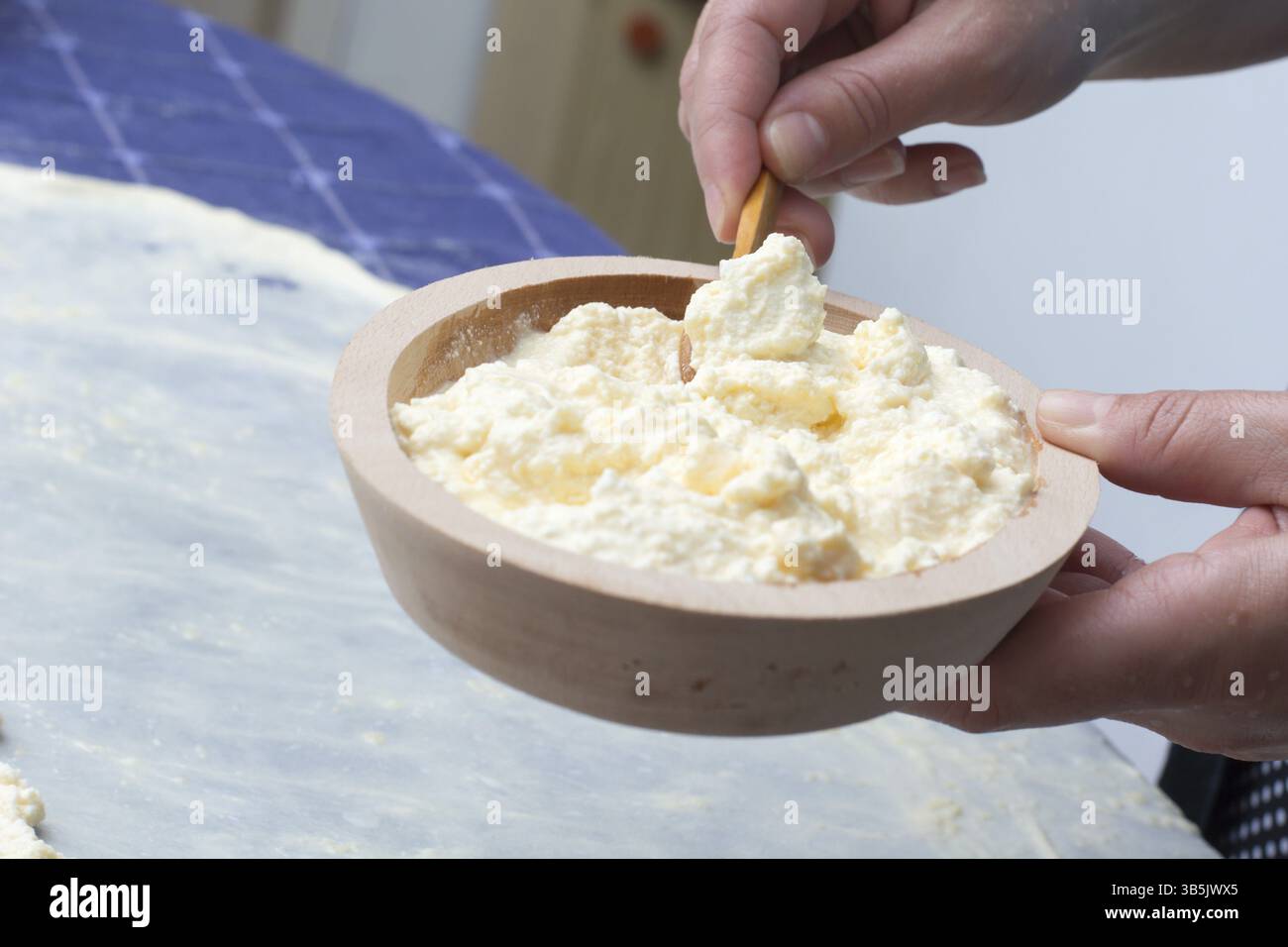 Fabrication de fromage fait maison tarte ou autre type de pâte. Mettre le fromage sur les mains des femmes de pâte filo sur la table de cuisine Banque D'Images