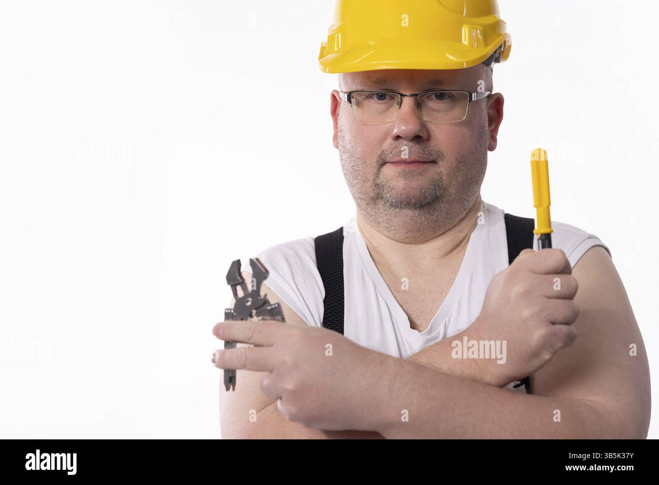 Un portrait détaillé d'un travailleur de la construction dévoué présentant fièrement divers outils et équipements de sécurité essentiels Banque D'Images