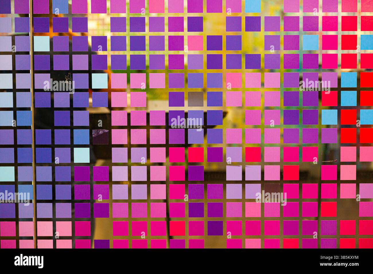 Mosaïque de petits carrés multicolores sur verre, gros plan. Carrés numériques multicolores de style matriciel. Banque D'Images