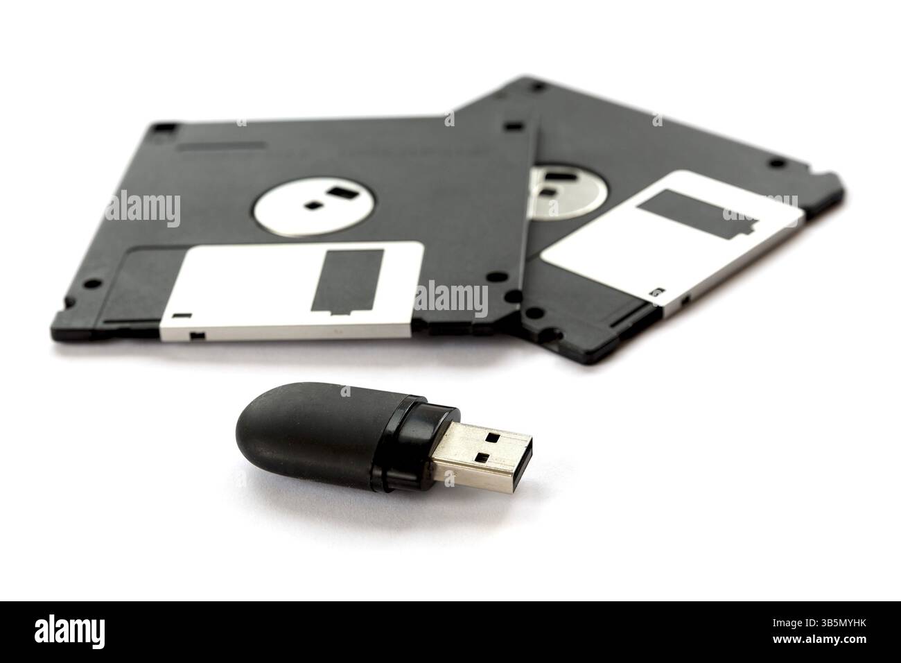 Deux disquettes noires et un lecteur flash isolé sur fond blanc Banque D'Images