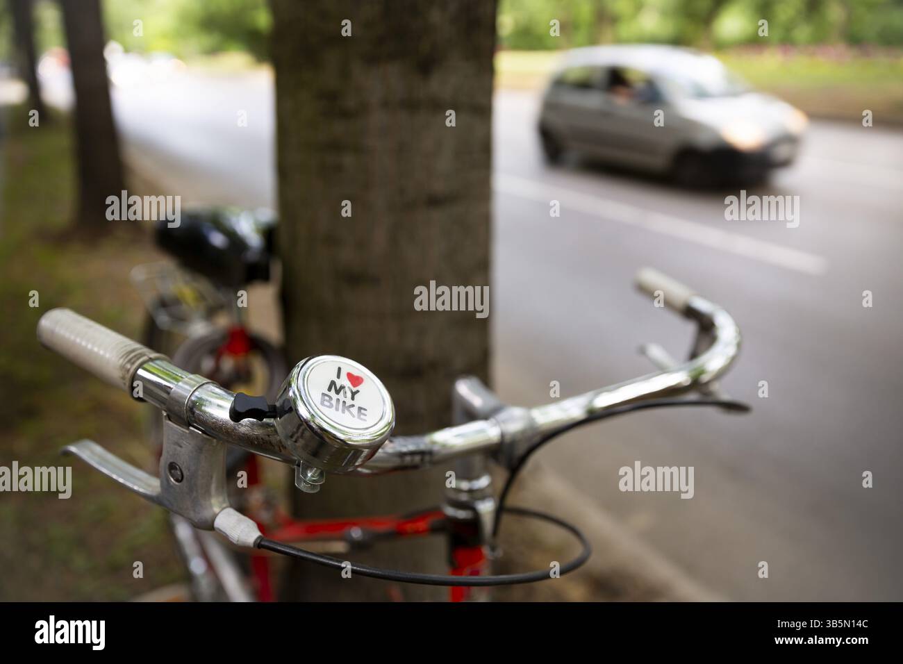 Vélos bordant un arbre à côté d'une rue de la ville avec une voiture. J'adore mon signe de vélo Banque D'Images