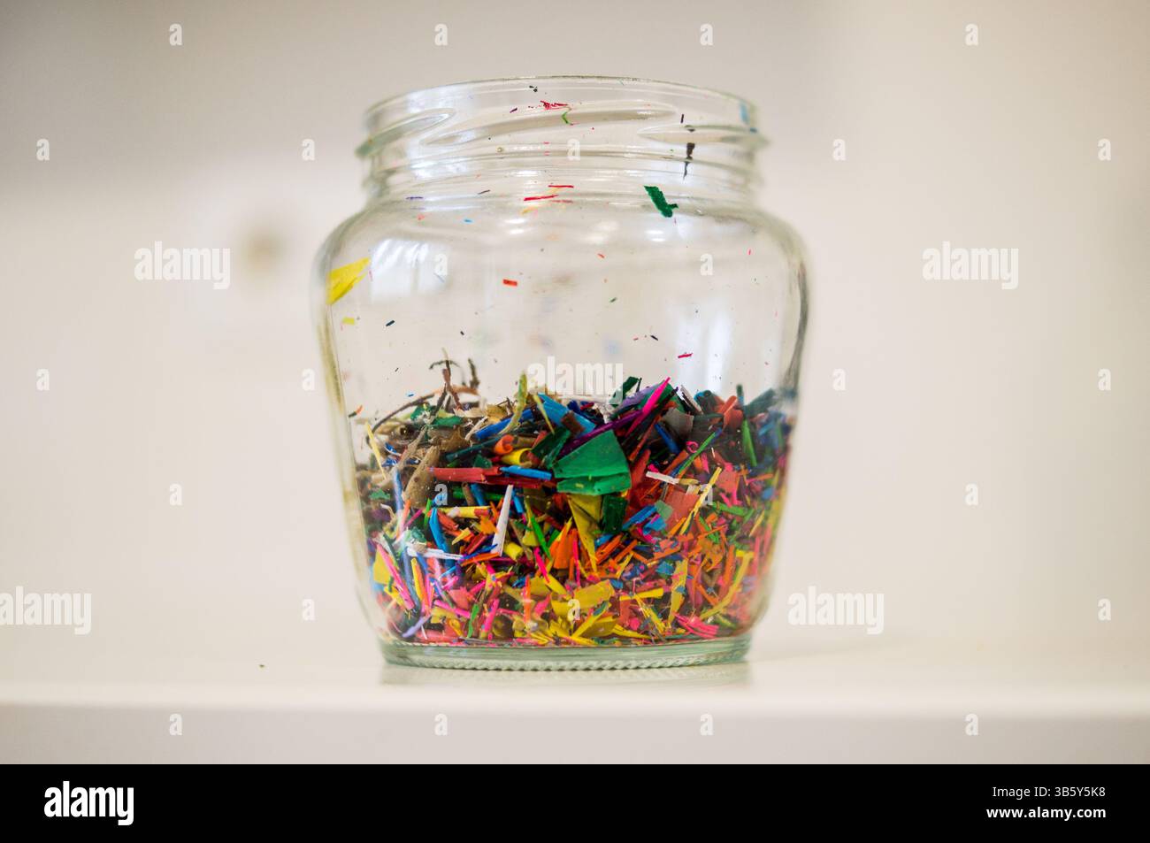 Photographie de détail d'un pot rempli des restes de taille-crayons de couleur Banque D'Images