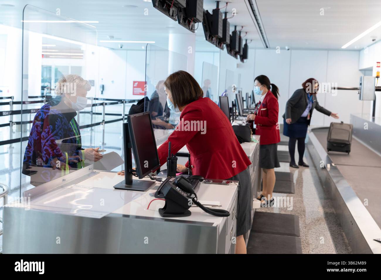 9 avril 2022, SeaTac, Washington, États-Unis : les employés des compagnies aériennes aident les bénévoles à enregistrer à nouveau leurs bagages lors d'une simulation de flux de passagers à l'installation internationale des arrivées de l'aéroport international Seattle-Tacoma à SeaTac, Washington, le samedi 9 avril 2022. La nouvelle installation de 450 000 pieds carrés du Port de Seattleâ™devrait ouvrir le mois prochain après la fin des tests finaux de préparation opérationnelle. (Crédit image : © Paul Christian Gordon/ZUMA Press Wire) Banque D'Images