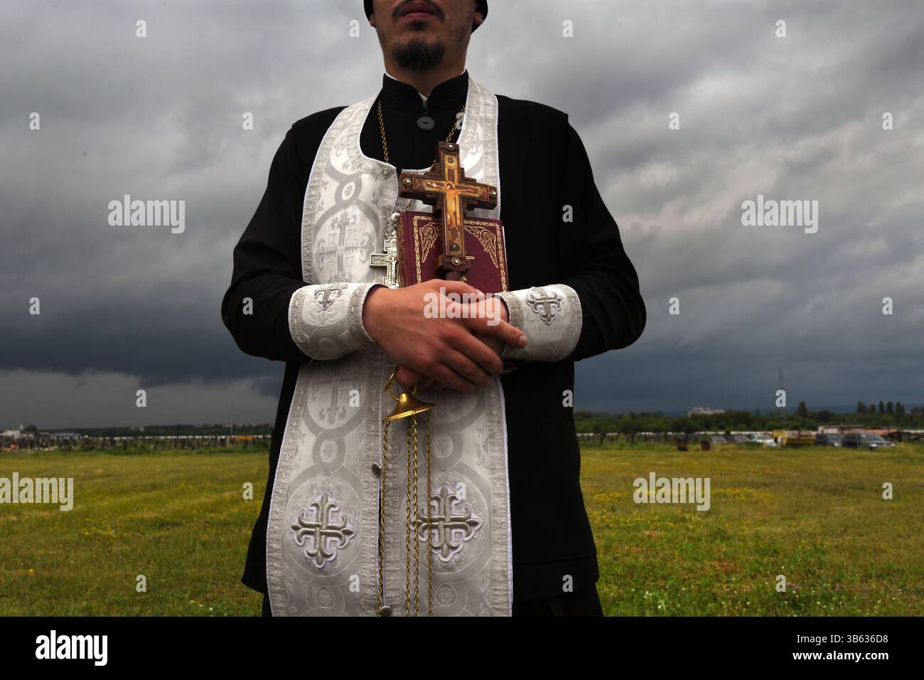 24 juin 2022, Kharkiv, Ukraine : un prêtre local à la périphérie de la ville de Kharkov au cimetière 18. C’est sur le héros de la course spatiale soviétique Y. Gagarine rue, Forces armées de l’Ukraine a déjà enterré plus de 100 soldats locaux, qui sont tombés devant les troupes russes sont enterrés. Comme auparavant avec l'Union soviétique, ils ont toujours souffert des attaques de guerre de la Russie, et le cimetière 18 met en valeur cette relation asymétrique. Les pierres tombales des combattants qui sont morts lors de l'attaque menée par Poutine dans le Donbass, il y a des années. À côté des morts d'hier sont les morts d'aujourd'hui et très probablement beaucoup plus demain an Banque D'Images