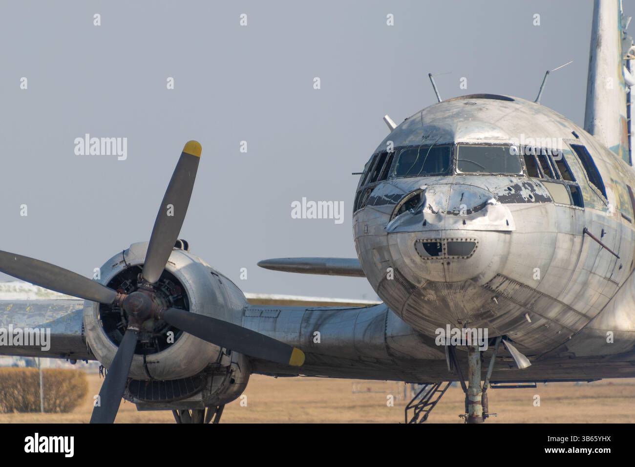 Vieil avion à hélice abandonné avec métal altéré, fenêtres fissurées et nez plié. Varsovie, Pologne. Banque D'Images