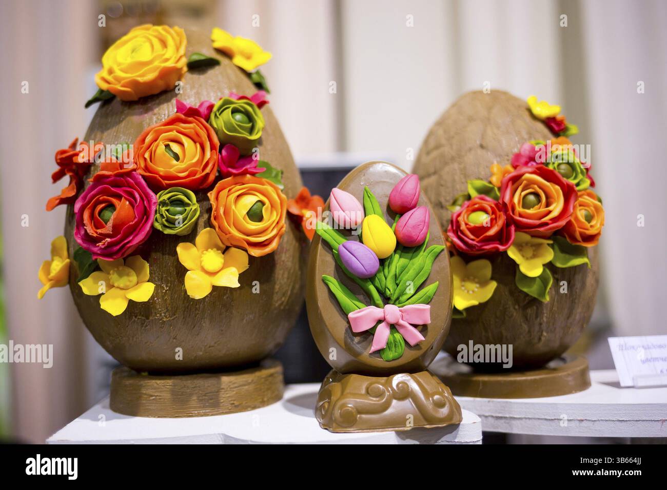 Les œufs en chocolat de Pâques avec des fleurs à la main à partir de bonbons. Tulipes colorées et différentes fleurs jaunes et roses. Très savoureux et délicieux dessert Banque D'Images