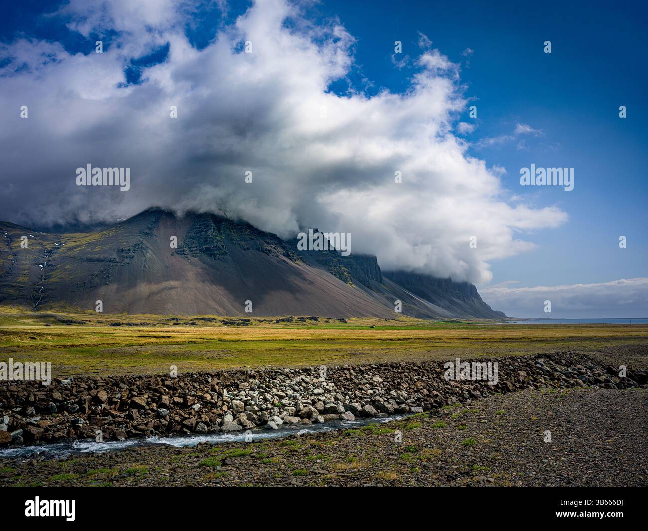 Nuages bas balayant sur les montagnes escarpées de l'est de l'Islande près de la côte Banque D'Images