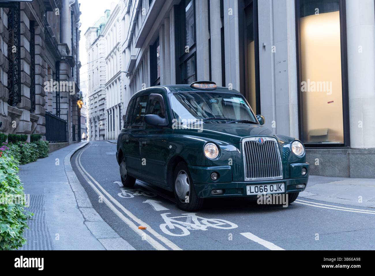 Vue de face d'un taxi Green London, conduisant le client dans le centre de Londres à l'approche d'un carrefour Angleterre Royaume-Uni Banque D'Images