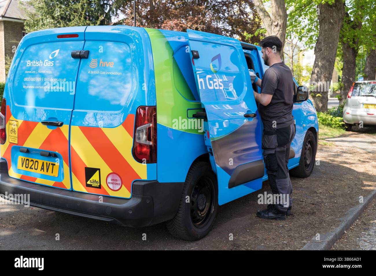 Ingénieur gaz britannique ouvre son van bleu en se préparant pour un travail sur site dans le domaine résidentiel de Londres Royaume-Uni Banque D'Images