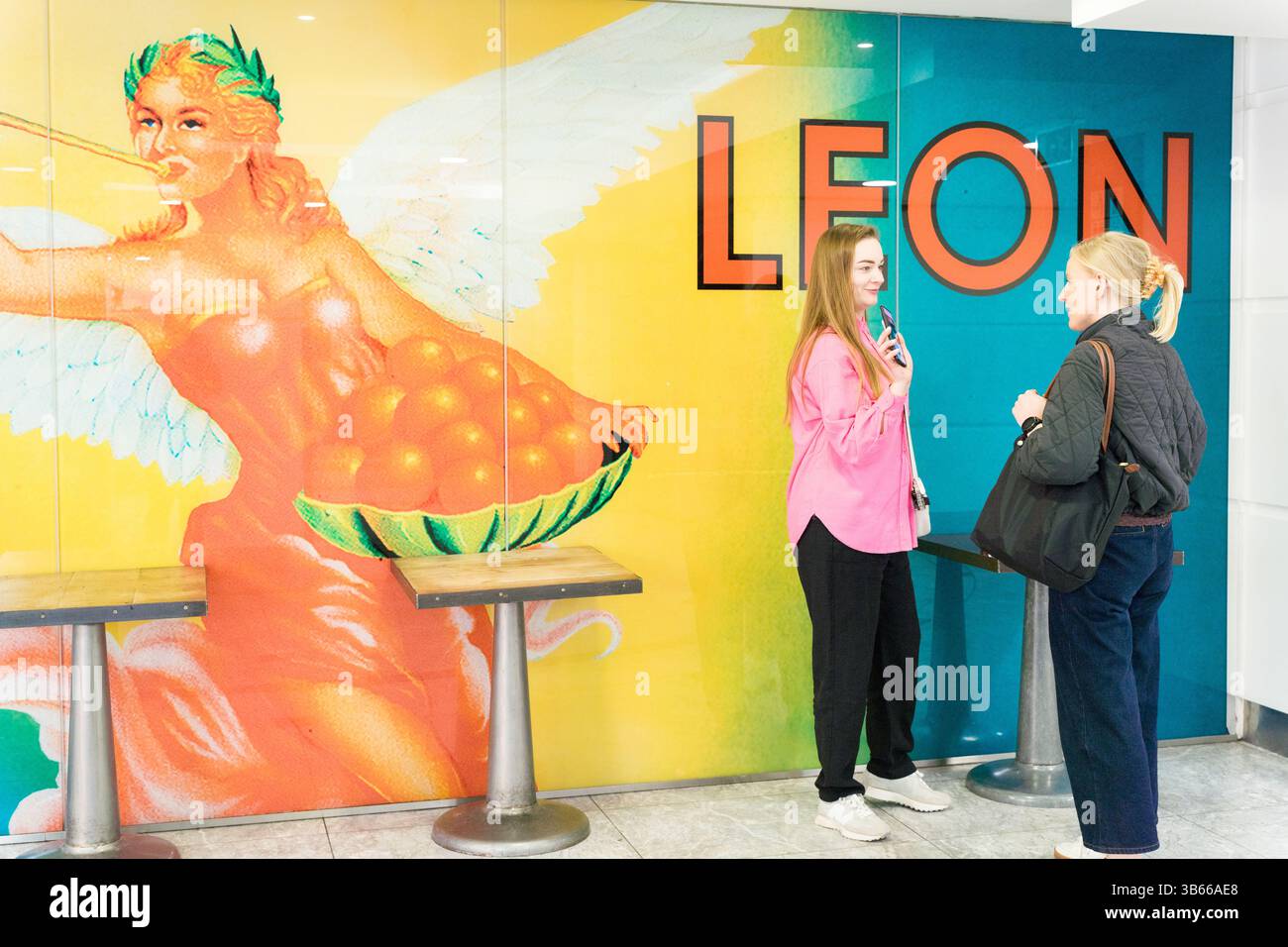Deux clientes en attente de leur commande au restaurant Leon fast food London UK Banque D'Images