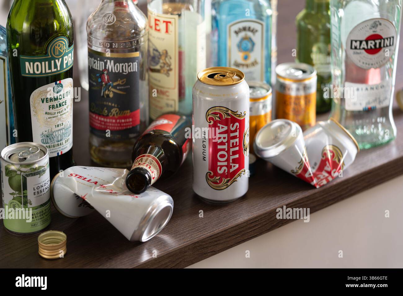 Canettes de bière vides et bouteilles de spiritueux sur un dessus de cuisine, Angleterre. Concept : alcoolique fonctionnel, alcoolisme, dépendance, choix de vie, mode de vie, booze Banque D'Images