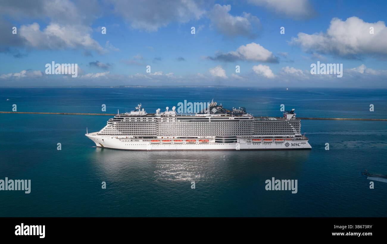 Navire de croisière de luxe MSC Seaview naviguant dans une mer bleue calme et un ciel clair avec reflet dans la mer Banque D'Images