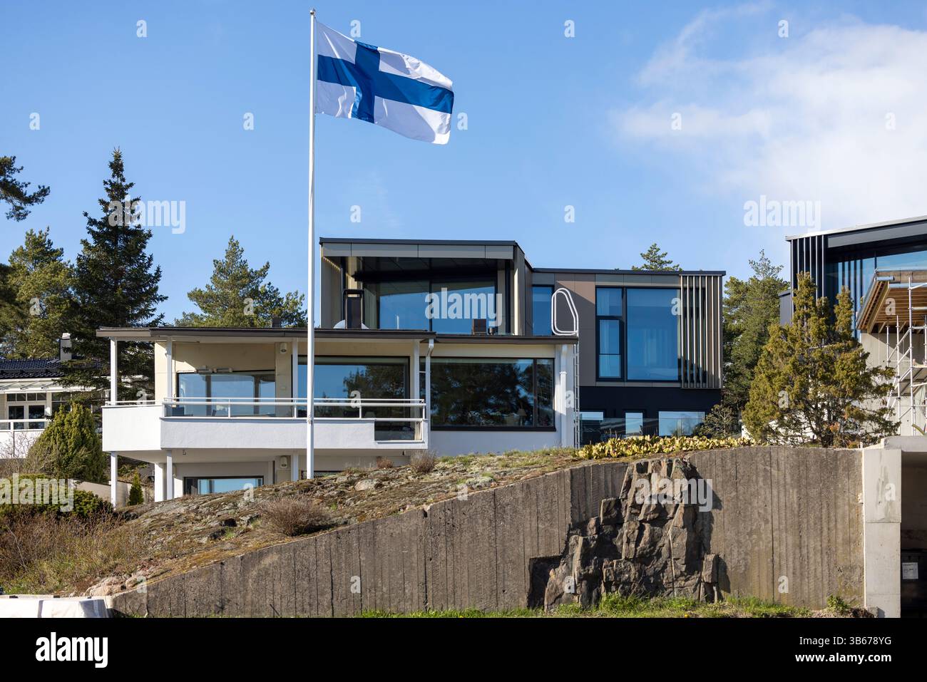 Drapeau finlandais flottant au-dessus d'une maison familiale à Westend, Espoo Banque D'Images