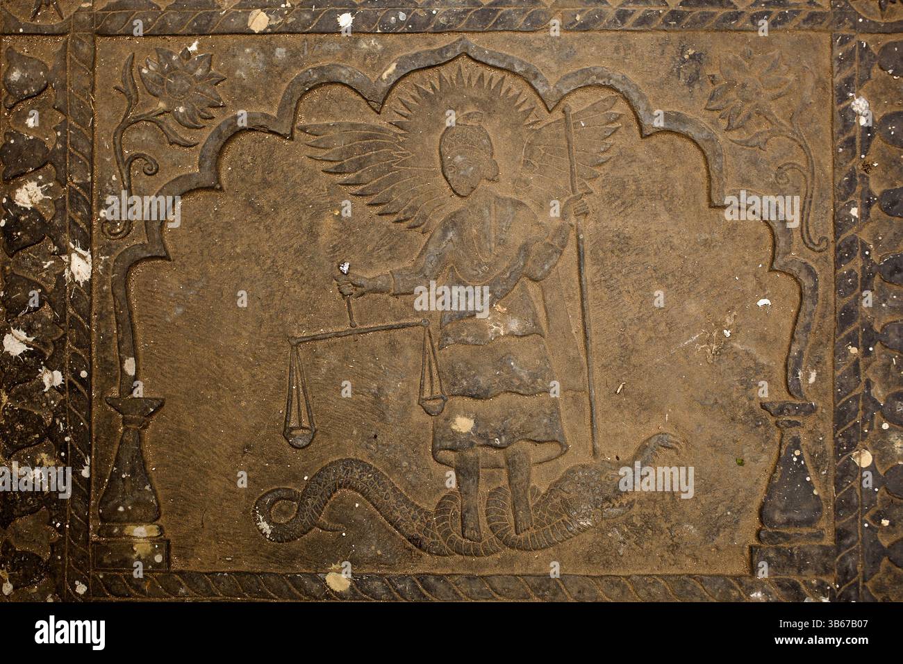Relief de l'Archange Michel pesant les âmes et piétinant un serpent, sculpté sur une pierre tombale au cimetière de l'église arménienne, Armanitola, Old Dhaka. Banque D'Images