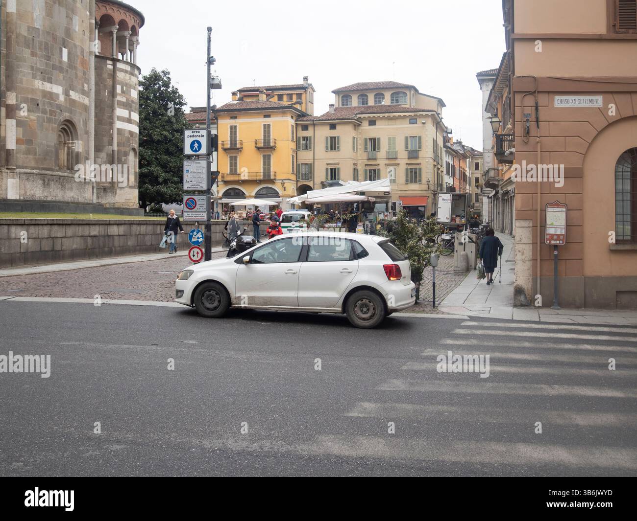 Cremona, Italie - 12 avril 2025 White Volkswagen Polo Hatchback garé soigneusement sur la rue pavée à côté du trottoir dans l'esprit animé du centre-ville européen Banque D'Images