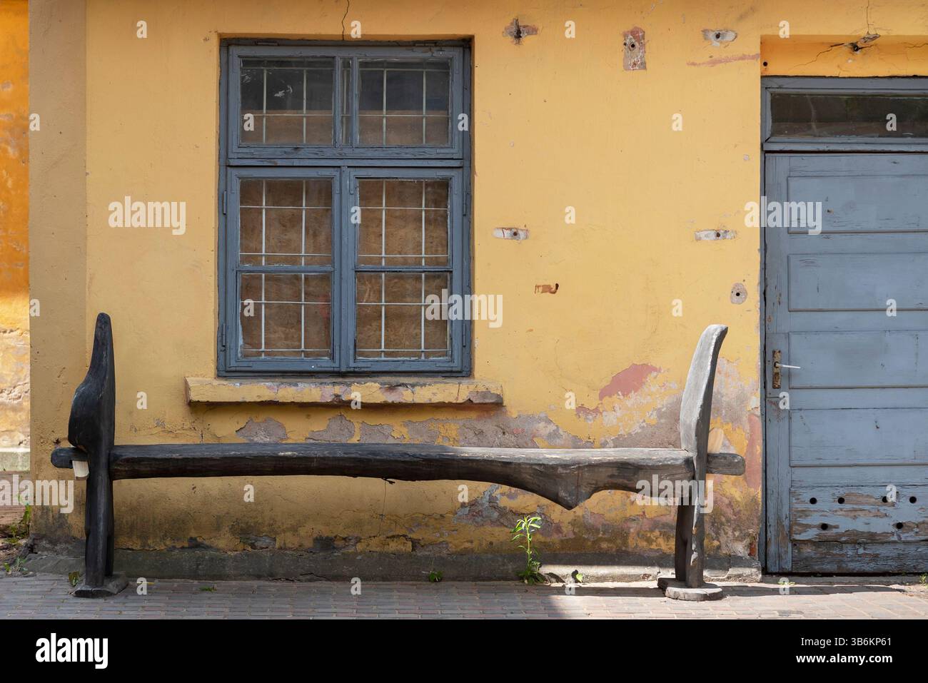 Un banc de style ancien à côté d'une maison non rénovée. Banque D'Images Un banc de style ancien à côté d'une maison non rénovée. Banque D'Images