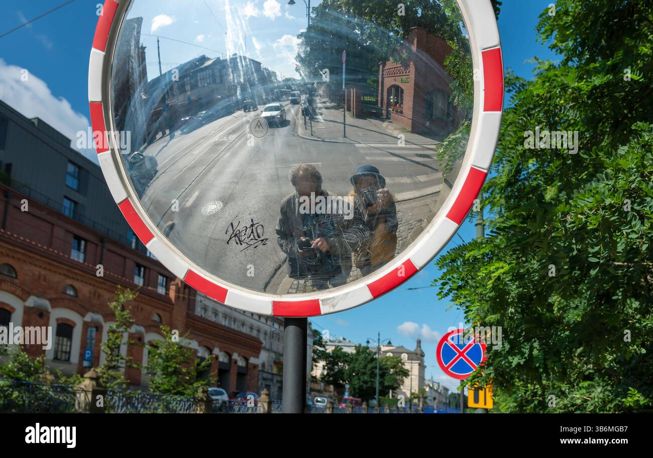 POLOGNE, CRACOVIE - 8 août : Cracovie est l'une des plus anciennes villes de Pologne. Vue du miroir de route avec le reflet de deux touristes le 8 août 2023 Banque D'Images POLOGNE, CRACOVIE - 8 août : Cracovie est l'une des plus anciennes villes de Pologne. Vue du miroir de route avec le reflet de deux touristes le 8 août 2023 Banque D'Images
