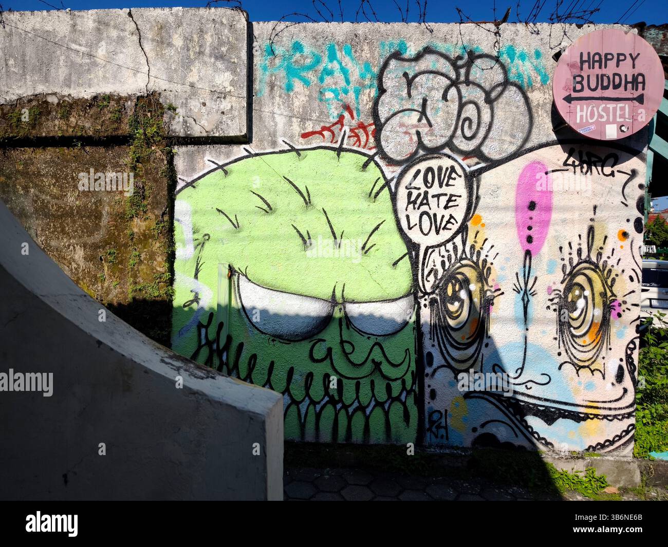 Travail mural sur le mur d'une ruelle combiné avec la signalisation d'une auberge Banque D'Images