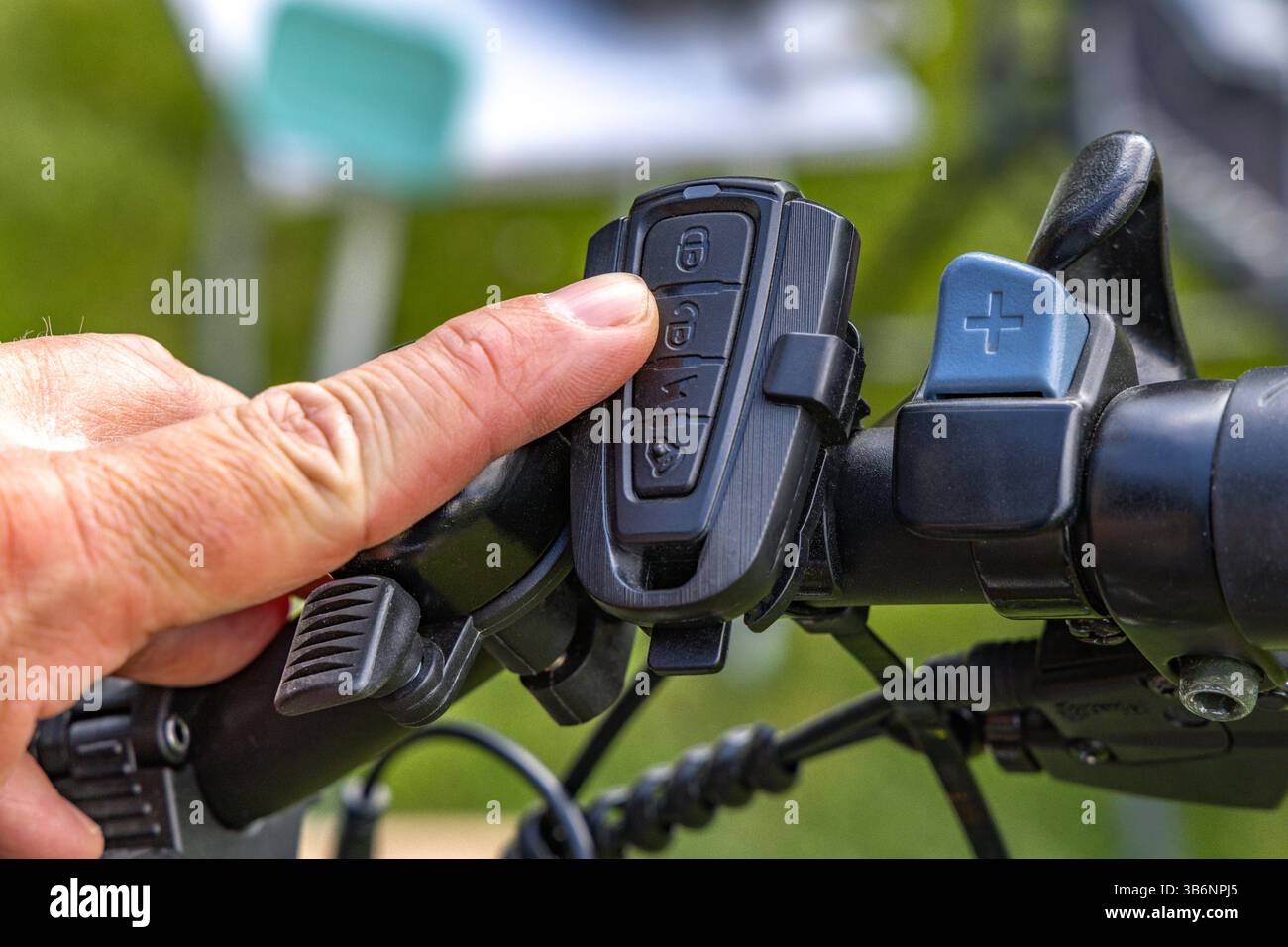 Cycliste allume l'alarme sur le vélo, activant la protection antivol à l'aide de la télécommande sur le guidon du vélo Banque D'Images
