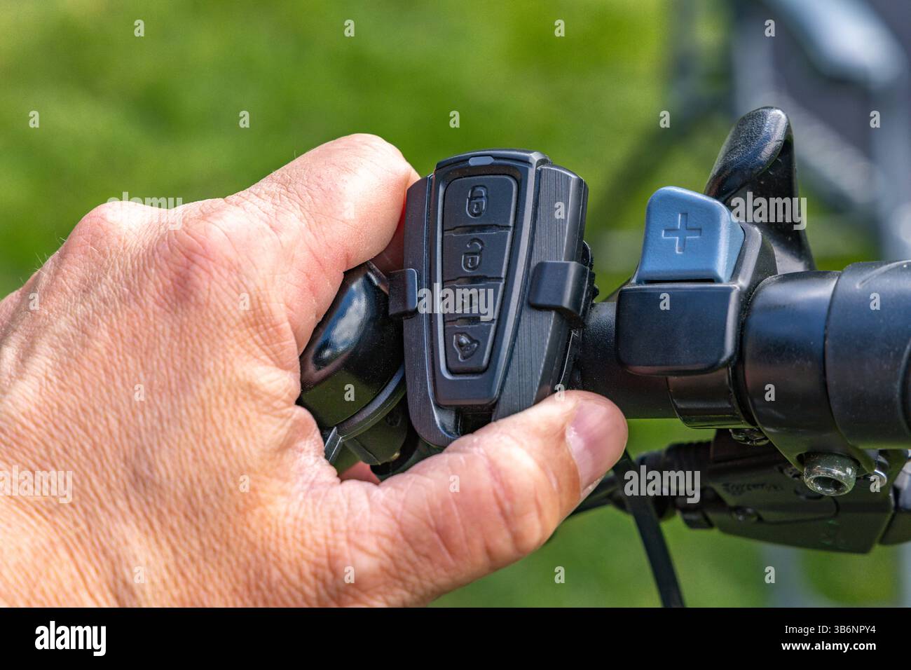 Cycliste allume l'alarme sur le vélo, activant la protection antivol à l'aide de la télécommande sur le guidon du vélo Banque D'Images