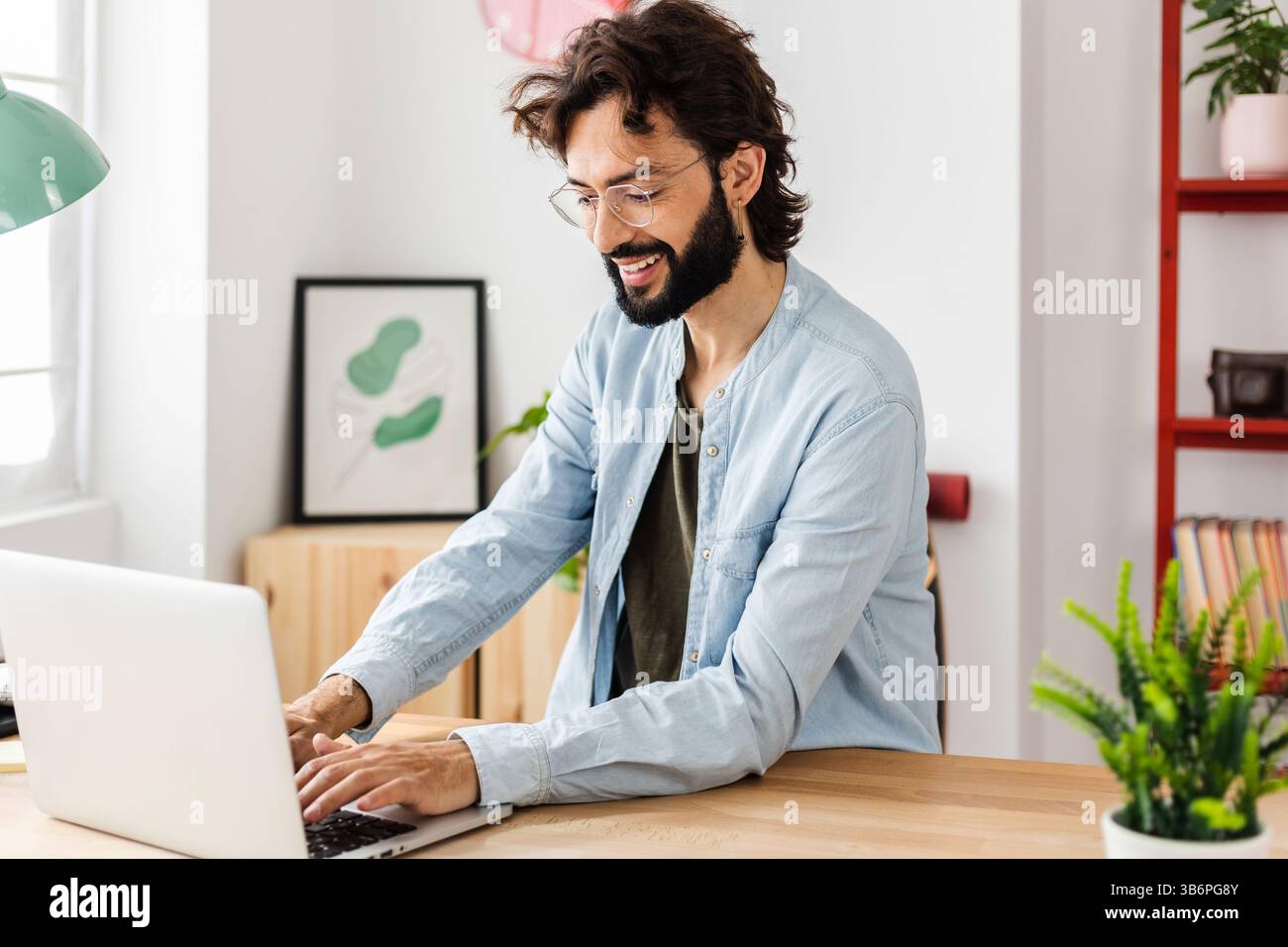 Homme d'affaires professionnel heureux travaillant sur ordinateur portable au bureau à domicile. Banque D'Images Homme d'affaires professionnel heureux travaillant sur ordinateur portable au bureau à domicile. Banque D'Images