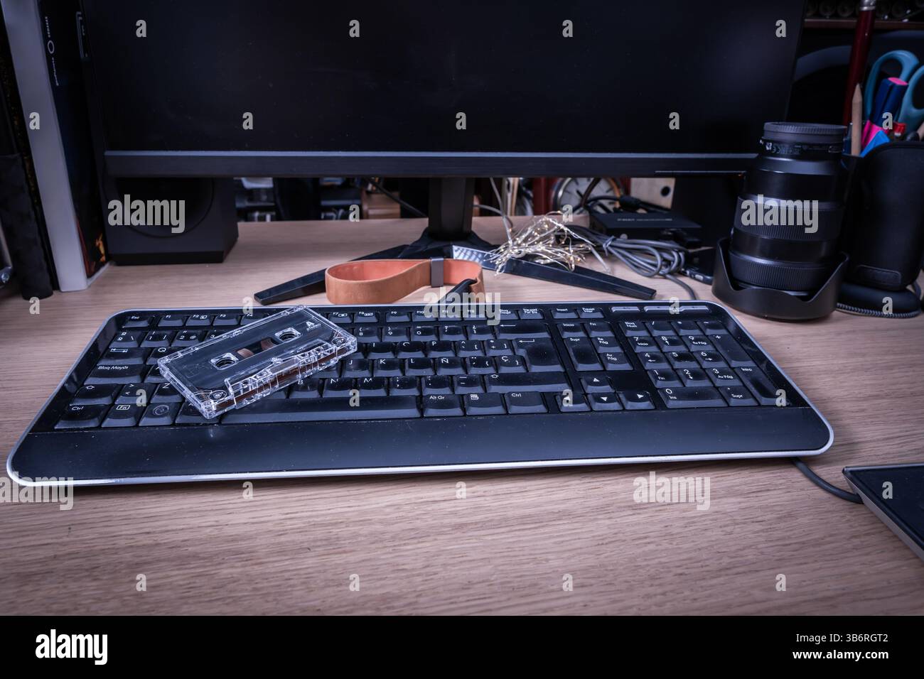 Cassette audio transparente posée sur un clavier d'ordinateur, mettant en valeur le contraste entre la technologie vintage et moderne Banque D'Images