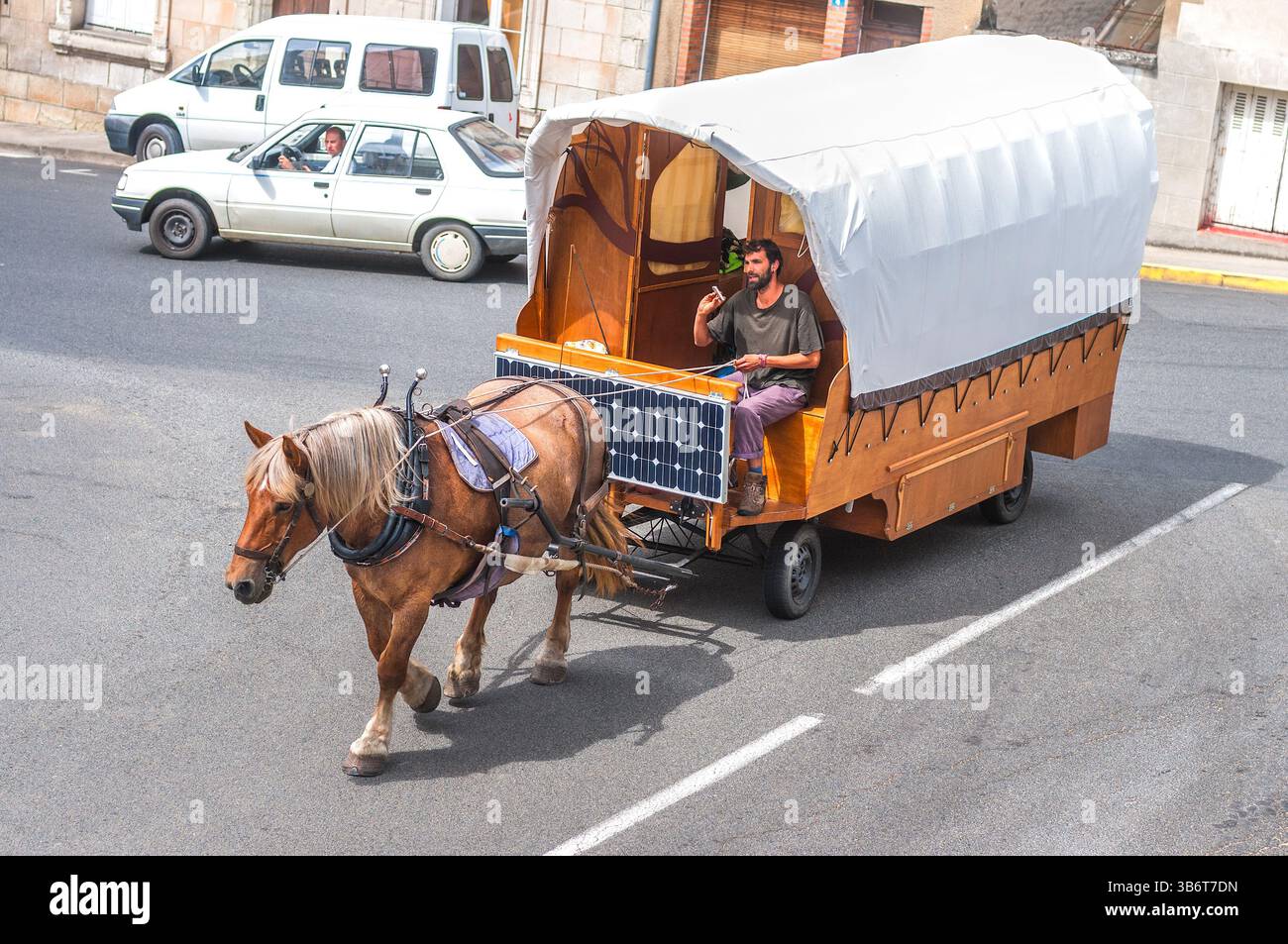 Caravane en bois tiré par des chevaux et en toile avec de jeunes voyageurs - centre de la France. Banque D'Images