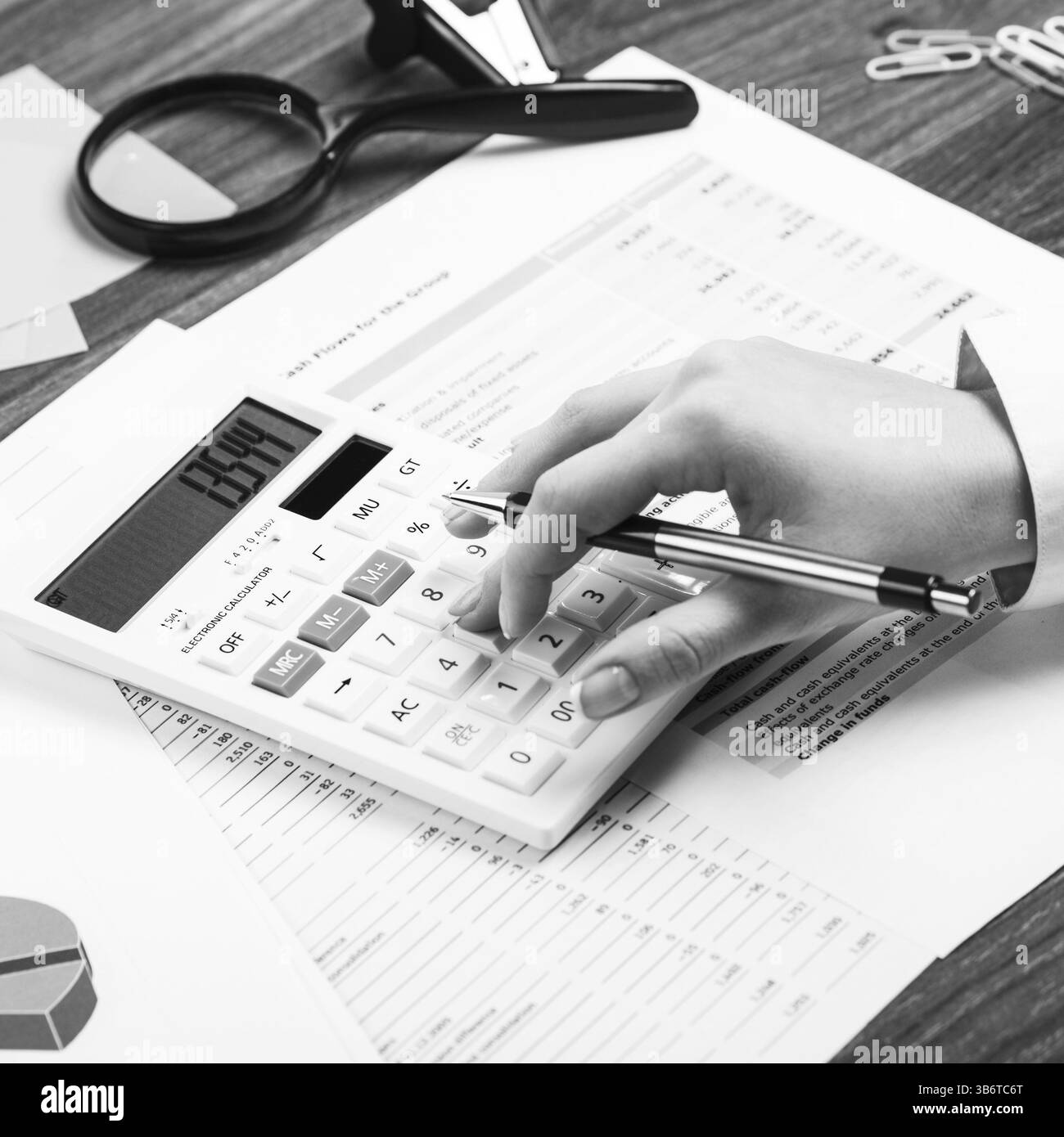 Gros plan d'une main féminine calculant, sur le bureau Banque D'Images